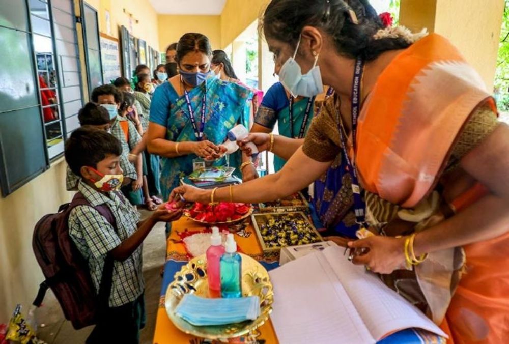 चेन्नई के एक स्कूल में क्लॉस आने वाले छात्रों का स्वागत करते शिक्षक