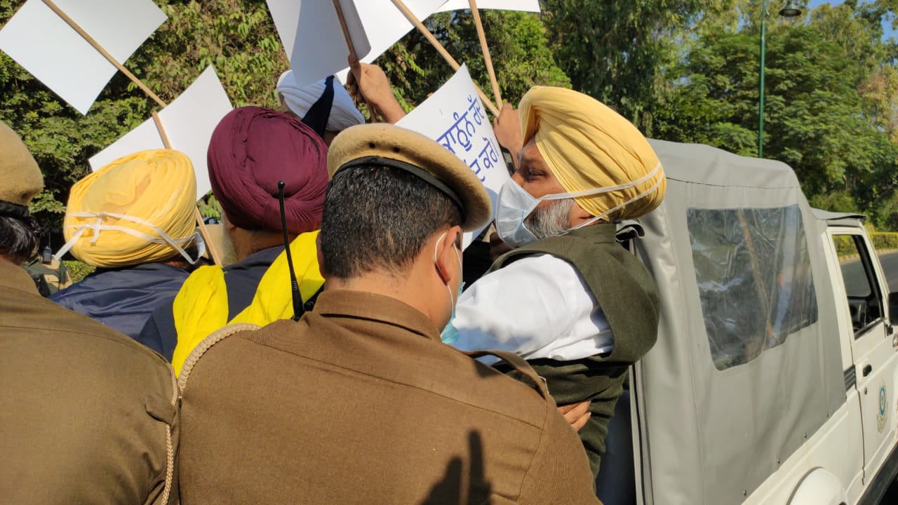 नए कृषि कानून के खिलाफ प्रदर्शन करते किसान को हिरासत में लेकर जाते सुरक्षा बल