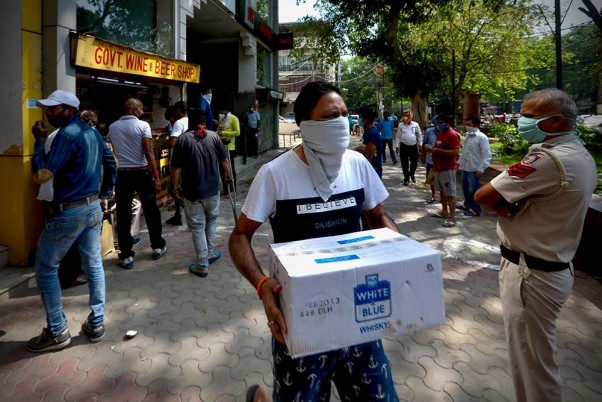 कोरोना के मद्देनजर छह सप्ताह तक लॉकडाउन के बाद सोमवार को फिर से खोली गई शराब की दुकानों के बाहर लाइन में लगे लोग