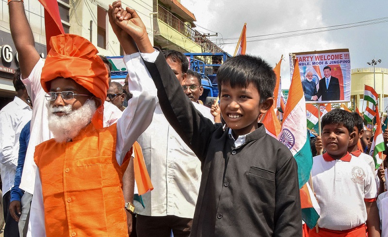 ममल्लापुरम में दूसरे अनौपचारिक भारत-चीन शिखर सम्मेलन से पहले एक रैली में भाग लेते प्रधानमंत्री नरेंद्र मोदी और चीनी राष्ट्रपति शी जिनपिंग के रूप में तैयार बच्चे