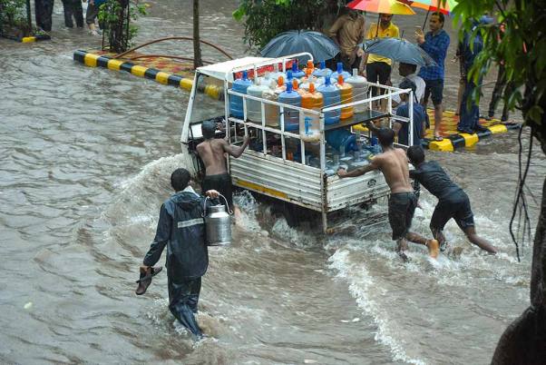 सूरत में भारी बारिश का कहर, जलभराव के कारण अपने वाहन को धक्का देते कर्मी