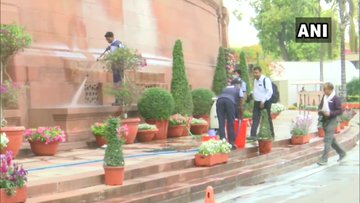 कोरोना वायरस के चलते संसद भवन परिसर की सफाई करते कर्मचारी