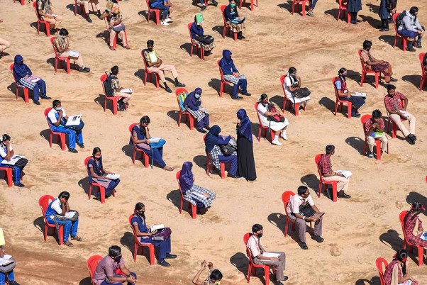 बेंगलूरू के एक परीक्षा सेंटर में एसएसएलसी परीक्षाओं में बैठते समय सोशल डिस्टेसिंग का ध्यान रखते छात्र
