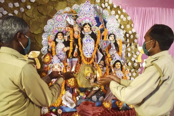प्रयागराज में चल रहे दुर्गा पूजा उत्सव के दौरान एक पंडाल में आरती करते भक्त
