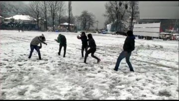 उत्तराखंड के नैनीताल में बर्फबारी का आनंद लेते पर्यटक