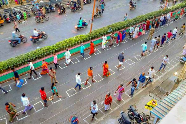 लॉकडाउन के दौरान चित्तूर के तिरुपति में जरूरी सेवाओं के लिए पास लेने के लिए सोशल डिस्टेंसिंग को ध्यान में रखते हुए लाइन में लगे लोग