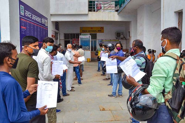 रांची में एक सरकारी अस्पताल में कोविड-19 टेस्ट के लिए अपने सैंपल देने के लिए कतारों में प्रतीक्षा करते लोग