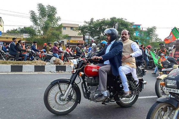 झारखंड विधानसभा चुनाव के तीसरे चरण से पहले एक चुनाव अभियान के दौरान रांची के पास खिजरी ब्लॉक में बाइक पर पीछे बैठकर जाते राज्य के मुख्यमंत्री रघुबर दास