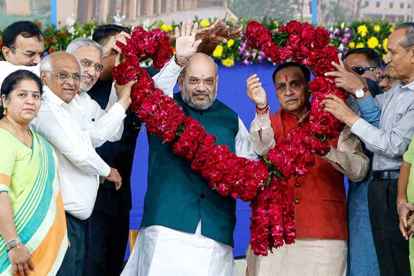अहमदाबाद में 800 करोड़ रुपये की विभिन्न विकास परियोजनाओं के उद्घाटन समारोह के दौरान केंद्रीय गृह मंत्री अमित शाह और गुजरात के मुख्यमंत्री विजय रूपानी का स्वागत करते भाजपा कार्यकर्ता