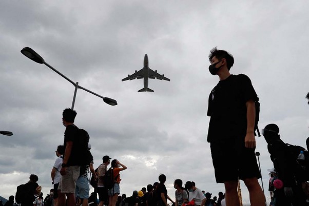 हांगकांग में हवाई अड्डे के बाहर इकट्ठा होते लोकतंत्र समर्थक प्रदर्शनकारी