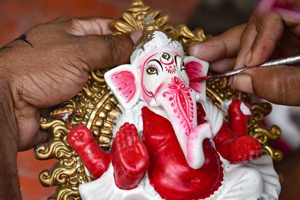 कुमारतुली में 'गणेश चतुर्थी' उत्सव से पहले भगवान गणेश की मूर्ति को अंतिम रूप देते कलाकार