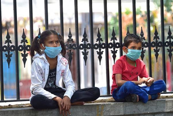लॉकडाउन के बीच अपने घर लौटने की व्यवस्था के लिए बेंगलूरू में जिला कलेक्टर कार्यालय के बाहर इंतजार करते प्रवासी मजदूर के बच्चे