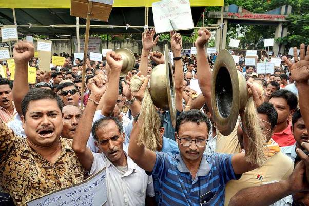 गुवाहाटी के बिजुल भवन में अपनी नौकरी को नियमित करने की मांग को लेकर नारेबाजी करते कर्मचारी