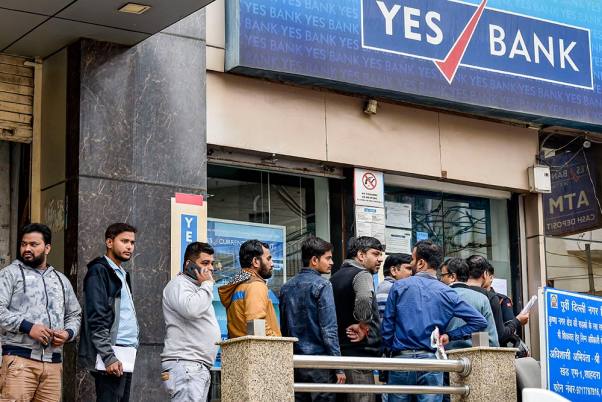 नई दिल्ली के कृष्णा नगर में यस बैंक से पैसा निकालने के लिए लाइन में खड़े खाताधारक