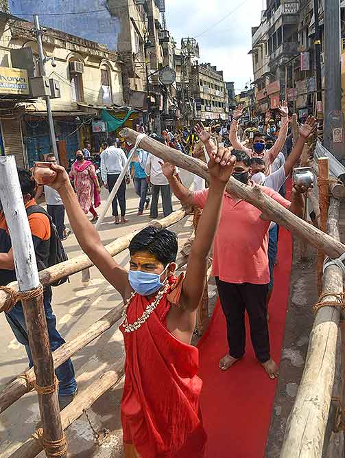 वाराणसी में 'सावन' के पवित्र महीने के पहले सोमवार के अवसर पर काशी विश्वनाथ मंदिर में भगवान शिव का 'अभिषेक' करने की प्रतीक्षा करते श्रद्धालु