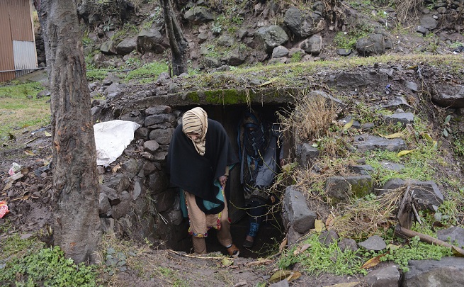 पीओके के सीमावर्ती शहर चकोटी में अपने घर के बाहर बने एक बंकर से निकलते लोग