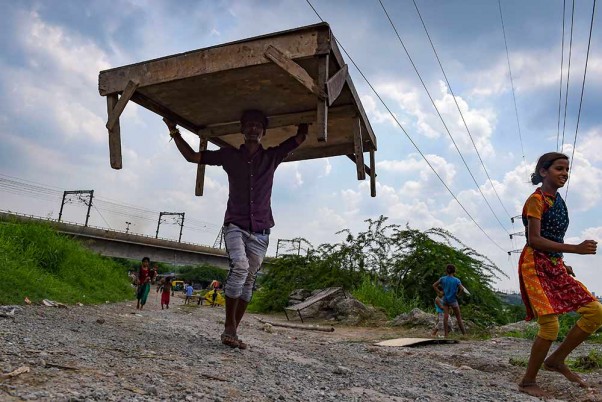 नई दिल्ली में यमुना नदी के किनारे निचले इलाकों में जल स्तर बढ़ने के बाद यहां रहने वाले लोग अपने सामानों को शिफ्ट करते हुए