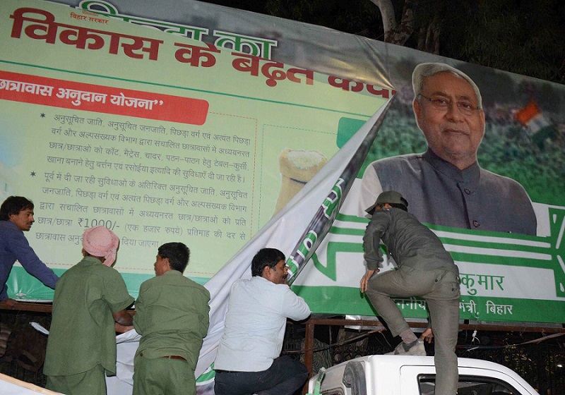 आचार संहिता का असर: लोकसभा चुनाव के लिए मतदान कार्यक्रम की घोषणा के बाद पटना में नगर निगम के कर्मचारियों ने एक राजनीतिक दल की होर्डिंग हटा दी