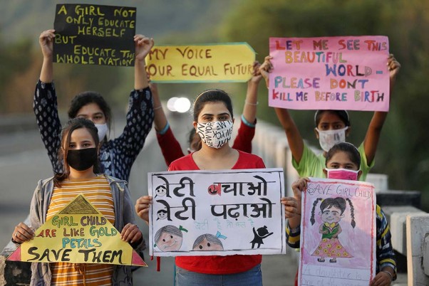 जम्मू में अंतर्राष्ट्रीय बालिका दिवस से पहले लैंगिक समानता के बारे में जागरूकता पैदा करने के लिए हाथ में तख्तियां लिए हुए युवा