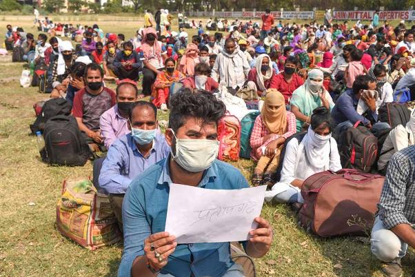 लॉकडाउन के चौथे चरण के दौरान सोनीपत के कुंडली औद्योगिक क्षेत्र में अपने मूल स्थानों पर जाने के लिए साधन की प्रतीक्षा करते प्रवासी श्रमिक