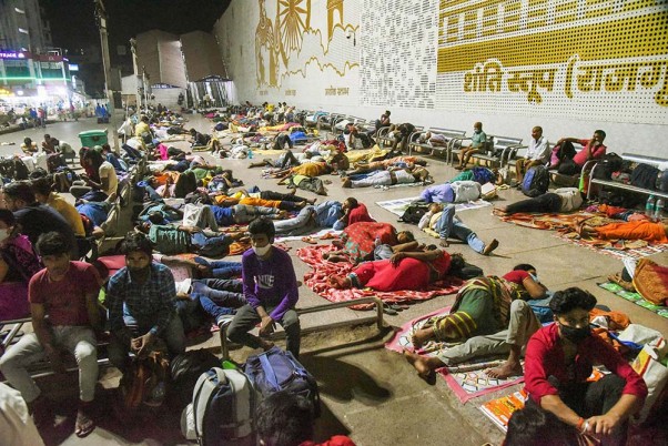 कोरोना महामारी के बीच पटना जंक्शन में आराम करते महाराष्ट्र से आए प्रवासी