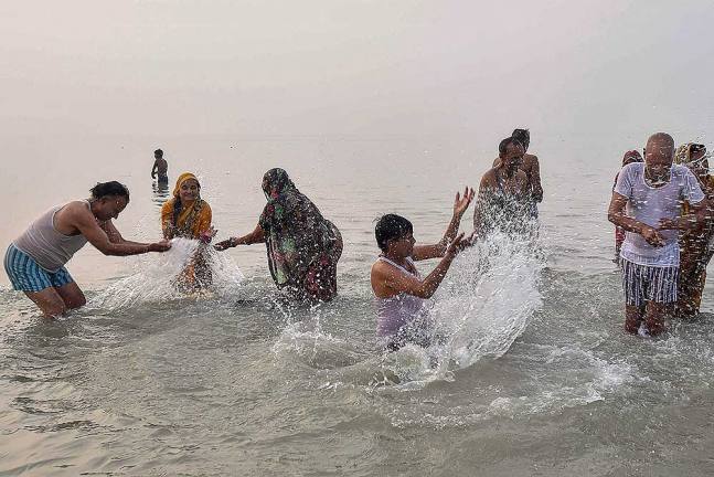 कोलकाता में मकर संक्रांति के अवसर पर गंगा में डुबकी लगाते श्रद्धालु
