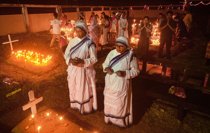 अगरतला में ऑल सोल्स डे के दौरान कैथोलिक ईसाई अपने परिवार के मृतक सदस्यों की कब्र पर मोमबत्तियां जलाते हुए