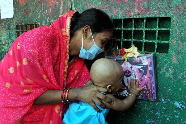 कोलकाता में चल रहे लॉकडाउन के दौरान 'स्नान यात्रा' उत्सव के अवसर पर कालीघाट काली मंदिर के बंद गेट के सामने प्रार्थना करते भक्त