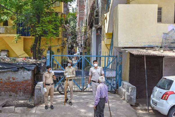 राजधानी दिल्ली में जारी लॉकडाउन के बीच कोविड-19 के हॉटस्पॉट्स इलाकों में से एक खिचड़ीपुर की एक कॉलोनी के बाहर तैनात पुलिसकर्मी