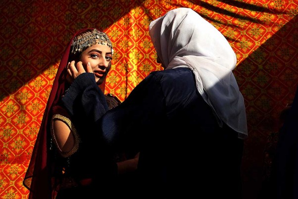 अफगानिस्तान के काबुल में एक फैशन शो से पहले मॉडल को तैयार करती महिला