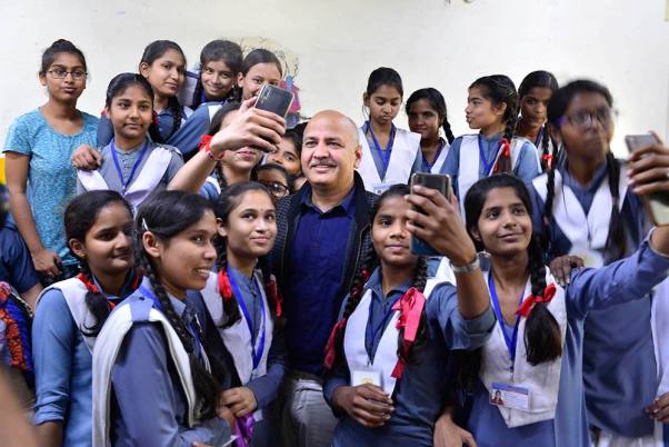 दिल्ली के गोकुलपुर गांव में जीबीएसएस स्कूल में पेरेंट्स-टीचर्स मीटिंग के दौरान स्कूली छात्रों के साथ सेल्फी के लिए पोज देते दिल्ली के उपमुख्यमंत्री मनीष सिसोदिया