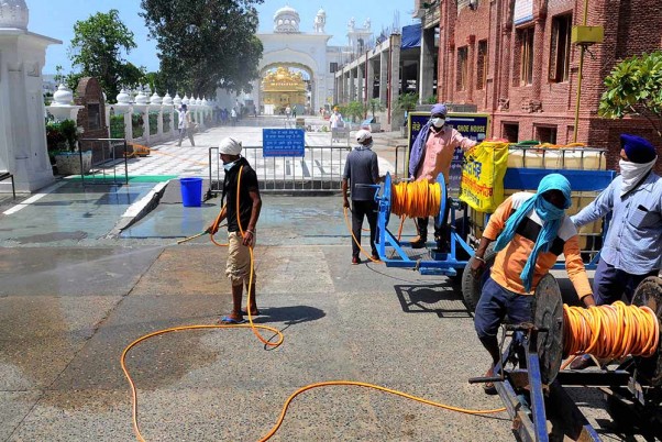 कोरोना वायरस महामारी के खिलाफ एक निवारक उपाय के रूप में अमृतसर के स्वर्ण मंदिर परिसर में कीटाणुनाशक का छिड़काव करते एसजीपीसी कार्यकर्ता