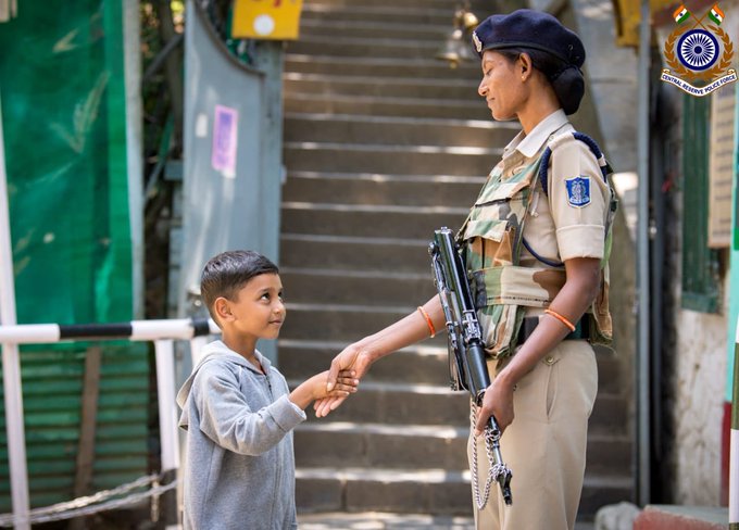 जम्मू-कश्मीर में अनुच्छेद 370 हटाने से पहले सुरक्षाबलों की तैनाती और धारा 144 लागू होने के बीच एक महिला सुरक्षाकर्मी से हाथ मिलाता स्थानीय बच्चा, सोशल मीडिया पर सुर्खियां बटोर रही ये तस्वीर