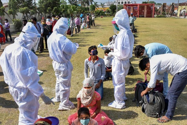 लॉकडाउन के दौरान स्पेशल ट्रेन से सुल्तानपुर अपने घर जाने से पहले स्वास्थ्य विभाग के अधिकारियों से तापमान की जांच करवाते श्रमिक