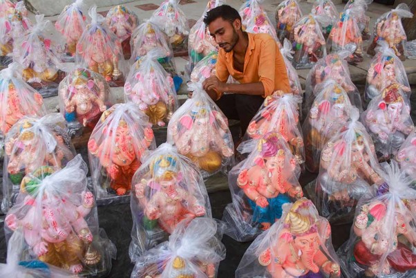 गुरुग्राम में गणेश चतुर्थी उत्सव की पूर्व संध्या पर मूर्तियों को बेचने के लिए ग्राहकों का इंतजार करता विक्रेता