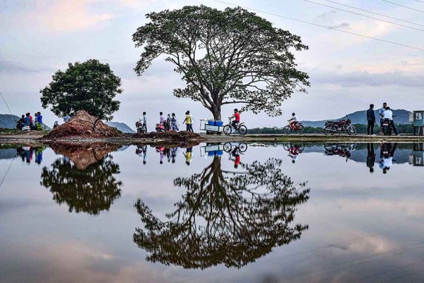 विजयवाड़ा में भारी बारिश के बाद साइकिल चलाते बच्चे