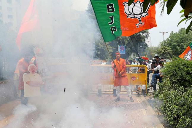 नई दिल्ली में भाजपा मुख्यालय के बाहर जीत का जश्न मनाते कार्यकर्ता