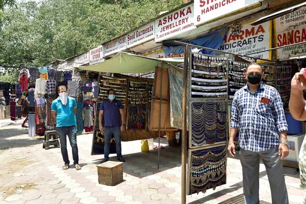 लॉकडाउन में छूट के बाद दिल्ली के कनॉट प्लेस स्थित जनपथ मार्केट में दुकान खुलने के बाद ग्राहकों का इंतजार करते दुकानदार