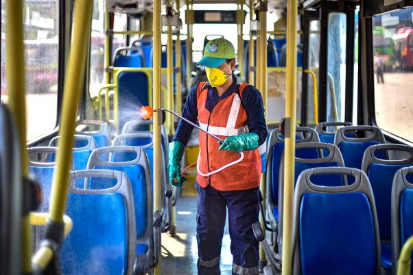 कोरोना वायरस महामारी के मद्देनजर नई दिल्ली के सरोजिनी नगर बस डिपो में डीटीसी बस के अंदर कीटाणुनाशक का छिड़काव करता स्वास्थ्य कर्मचारी