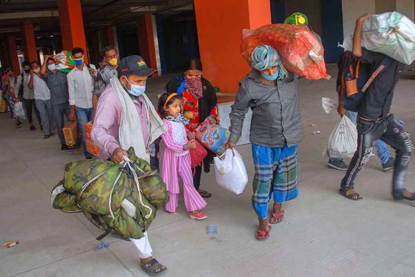 नोएडा में लॉकडाउन के दौरान रेलवे स्टेशन तक पहुंचने के लिए बॉटनिकल गार्डन में बस की ओर जाते प्रवासी श्रमिक