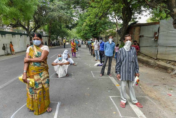 लखनऊ में प्रधानमंत्री गरीब कल्याण अन्न योजना के तहत भोजन लेने के लिए सोशल टिस्टेंसिंग के साथ कतार में खड़े लोग