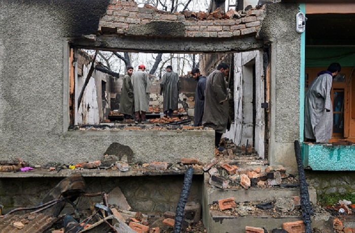 पुलवामा जिले में त्राल के पिंगलिश इलाके में सोमवार को सुरक्षाबलों और आतंकवादियों के बीच मुठभेड़ के बाद एक ध्वस्त घर का मुआयना करते ग्रामीण