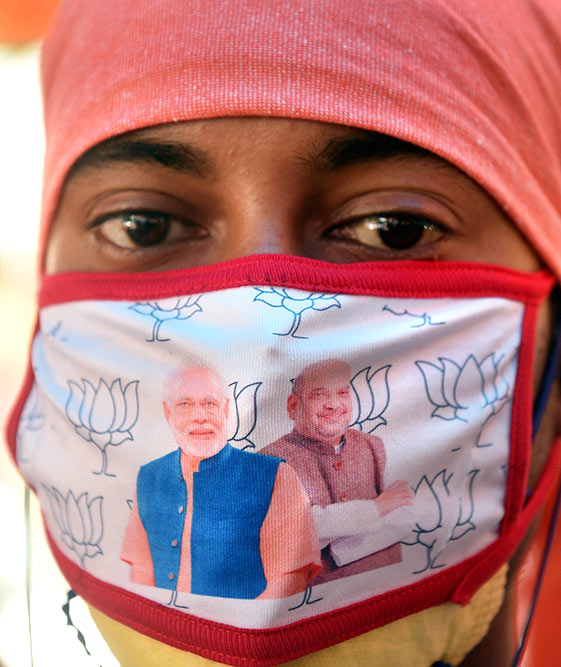 लॉकडाउन के दौरान कोलकाता के भाजपा कार्यालय में प्रधानमंत्री नरेंद्र मोदी और गृह मंत्री अमित शाह की एक साथ तस्वीरों वाला मास्क लगाए पार्टी कार्यकर्ता