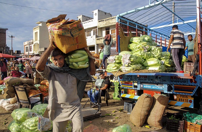 प्रतिबंधों के बीच जम्मू के एक बाजार से सब्जियां ले जाता शख्स