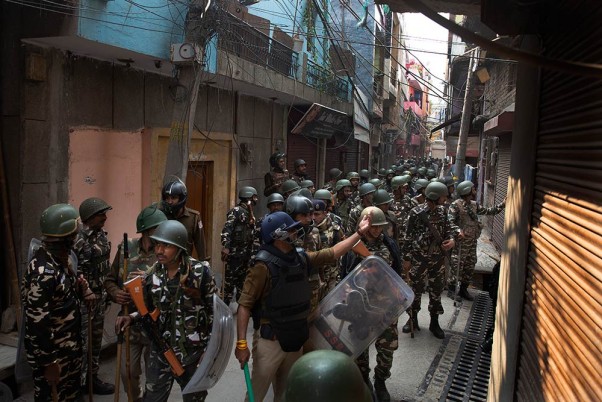 मंगलवार को राजधानी दिल्ली में हिंसा के बाद लोगों को अपने घरों में वापस जाने के लिए कहते अर्धसैनिक बल के जवान