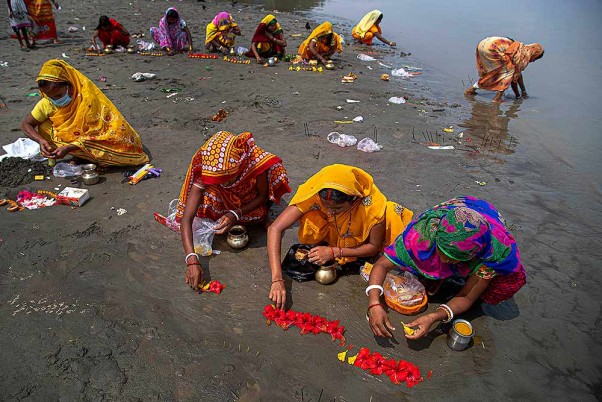 कोरोना वायरस से छुटकारा पाने के लिए गुवाहाटी में ब्रह्मपुत्र नदी के तट पर पूजा-अर्चना करती महिलाएं