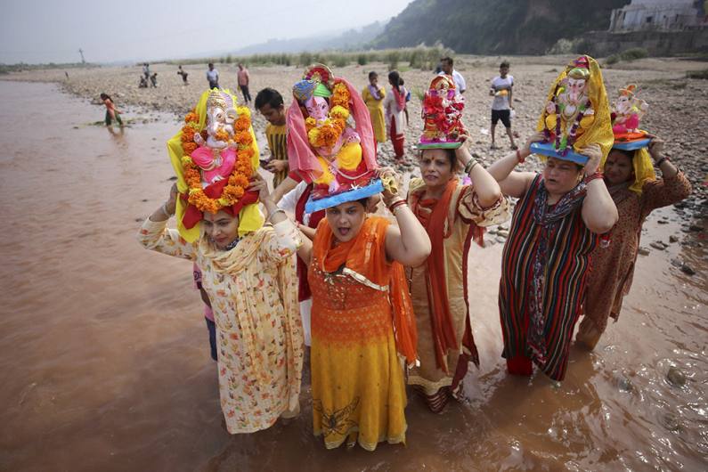 जम्मू में तवी नदी में विसर्जन के लिए भगवान गणेश की मूर्ति ले जाते श्रद्धालु