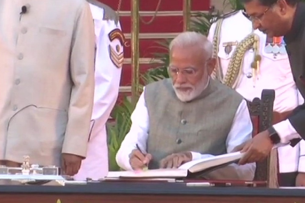 प्रधानमंत्री पद की शपथ लेने के बाद हस्ताक्षर करते नरेंद्र मोदी