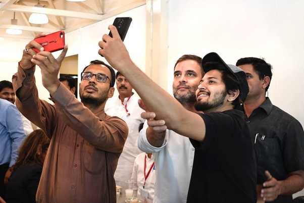 अहमदाबाद में सरदार वल्लभभाई पटेल अंतरराष्ट्रीय हवाई अड्डे पर लोगों के साथ सेल्फी लेते राहुल गांधी