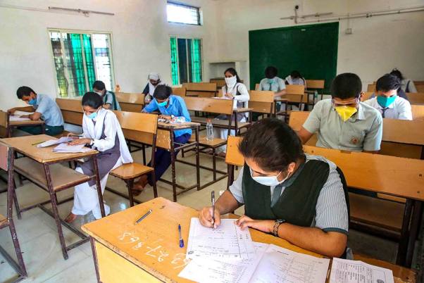 भोपाल में चल रहे लॉकडाउन के पांचवें चरण के दौरान मास्क पहनकर हायर सकेंड्री की बची हुई परीक्षा देते छात्र